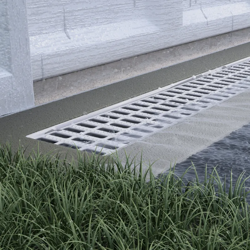 Channel drain with grate installed along a landscaped edge