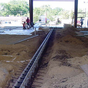 Commercial trench drainage system installed across a concrete truck court